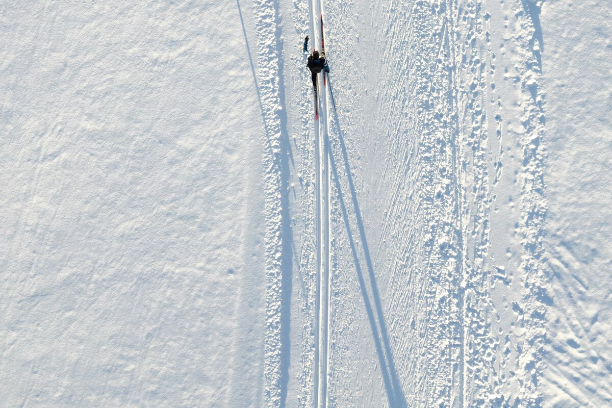 Hiihtäjä perinteisellä tyylillä lumisessa metsässä